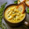 A bowl of creamy Cheddar Garlic Potato Soup garnished with fresh herbs and crispy bacon, showcasing a Hearty Cheddar Garlic Herb Potato Soup perfect for fall.