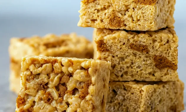 Stack of gooey Rice Krispie Treats made with cookie butter, crushed Biscoff cookies, and marshmallows — the ultimate Krispie Treats Recipe and one of the easiest Biscoff Recipes for chewy Cereal Treats and quick Easy Summer Desserts.