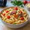 Bowl of colorful Greek Pasta With Feta featuring cherry tomatoes, Kalamata olives, crumbled feta, and fresh herbs, tossed in olive oil and served as a bright Mediterranean Pasta Dish.