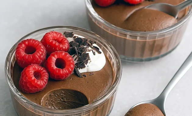 Glass jar of silky chocolate pudding topped with berries and cacao nibs, made from Blended Chia Seeds.