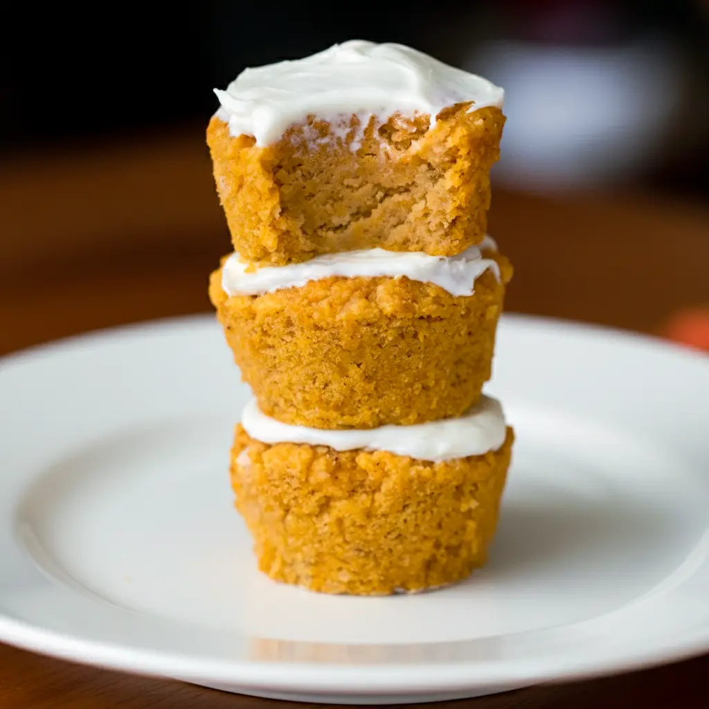 Close-up of golden, tender muffins studded with pumpkin spice and seeds, labeled Pumpkin Muffins High Protein.