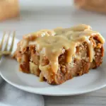 Slice of apple dapple cake with brown-sugar glaze and walnuts on a plate — perfect for Apple And Cranberry Recipes, a homey take on Apple Pie Pound Cake, and a smart way to use Things To Can With Apples or other Excess Apple Recipes.