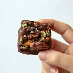 Close-up of Dark Chocolate Nut Squares made with roasted Baking Nuts, crunchy Chocolate Nuts, and Pumpkin Pecan mix, drizzled with dark chocolate — a Super Yummy, Healthy Dessert and Power Snacks alternative to Sugary Snacks, perfect as High Protein Snacks or homemade Crunch Bar treats.