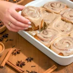 Golden chai cinnamon rolls arranged in a pan, gooey brown-sugar chai caramel at the base, topped with chai cream cheese frosting — a cozy Chai Cinnamon Rolls Recipe perfect for September Dessert Recipes and Personal Sized Desserts, with a salted finish for Desserts With Salt, featured in Rolled Food Ideas, a classic Dessert With Yeast, part of Fancy But Easy Recipes, worthy of Bake Off Winning Recipes, and inspired by Recipes With Chai.