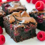 Close-up of fudgy brownies with glossy jam swirls and fresh berries — Raspberry Topped Brownies that read like a Brownie Raspberry Dessert and one of the best Chocolate Raspberry Dessert Recipes, dotted with juicy Brownies With Raspberries.