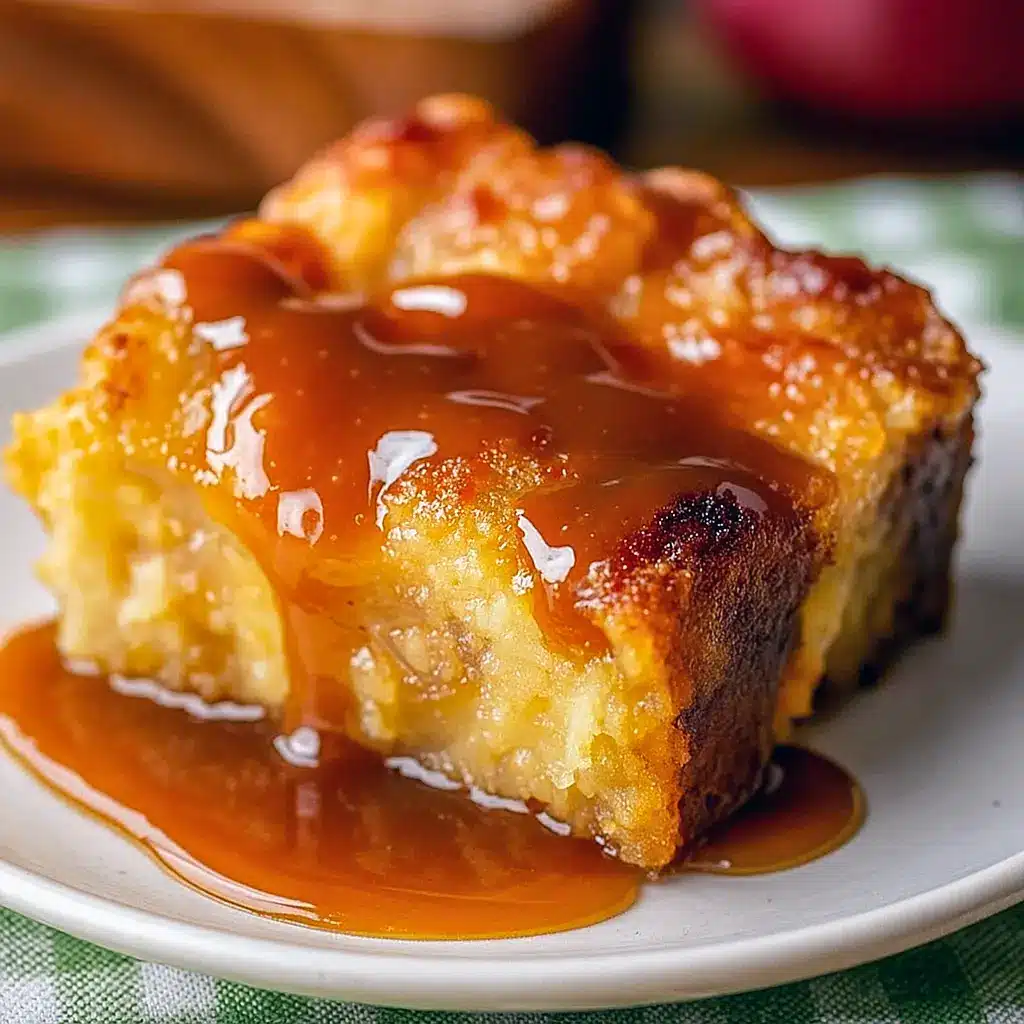 Close-up of whiskey caramel bread pudding with glossy caramel drizzle, golden-brown custardy top, and a side of fresh berries — plated with a scoop of vanilla ice cream, Caramel Sauce.
