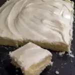 Almond Sheet Cake Recipe: Golden almond sheet cake in a greased Sheet Cake Pan, sliced like a Dessert Bar, topped with glaze, chopped nuts and mini Marshmallows, a tempting photo for fans of Sheet Cake Recipes, Almond Cakes, Food Cakes, Yummy Sweets and other Decadent Cakes.