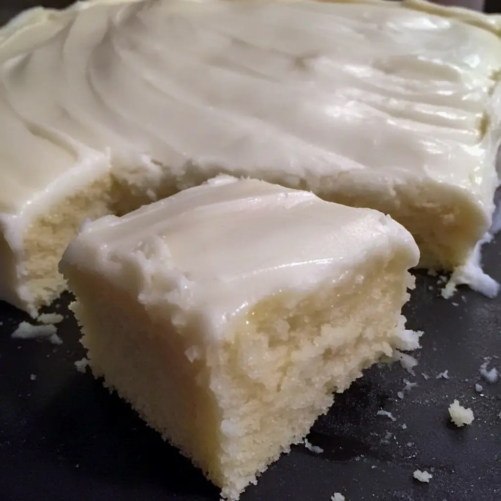 Almond Sheet Cake Recipe: Golden almond sheet cake in a greased Sheet Cake Pan, sliced like a Dessert Bar, topped with glaze, chopped nuts and mini Marshmallows, a tempting photo for fans of Sheet Cake Recipes, Almond Cakes, Food Cakes, Yummy Sweets and other Decadent Cakes.