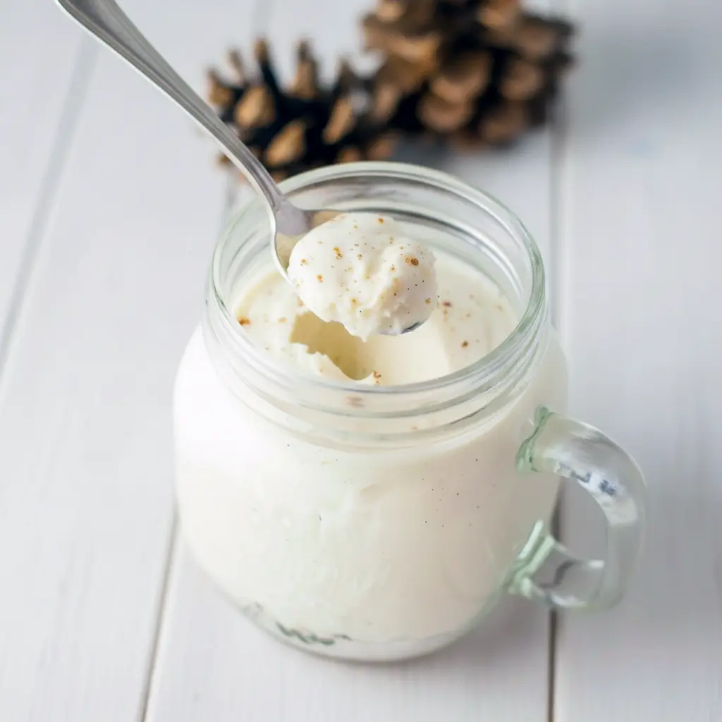 Eggnog Mousse Recipe: creamy eggnog mousse in a mason jar topped with gingerbread streusel and a light dusting of nutmeg.