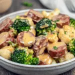 Cheesy broccoli and cauliflower au gratin with browned sausage baked in a casserole dish — an easy, comforting keto recipe featuring Low Carb Meals With Sausage, ideal for Keto Small Meals or Keto Friendly Lunch.