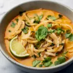 Bowl of creamy Easy Thai Chicken Curry Soup filled with noodles, tender chicken, herbs, and coconut-curry broth, perfect for fans of Easy Thai Soup Dinner Ideas, Thai Ginger Chicken Soup, Easy Thai Soup, Salt And Lavender Thai Chicken Soup, Easy Thai Chicken Curry Soup Salt And Lavender, flavorful Thai Soup Recipes Easy, cozy Ginger-spice Chicken Soup, and vibrant Thai Curry Soup Recipes.