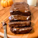 Moist chocolate pumpkin bread loaf sliced on a wooden board, showcasing a rich, dark crumb with chocolate chips — a cozy fall treat inspired by Pumpkin And Chocolate, perfect for fans of wholesome seasonal baking.