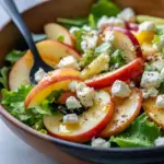 Close-up of a Honeycrisp apple and feta salad — arugula, thin apple slices, pomegranate seeds, candied pecans and crispy prosciutto, all drizzled with apple-cider vinaigrette, Fresh Salad Recipes.