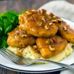 Pecan Chicken on mashed potatoes topped with toasted pecans and glossy sauce.