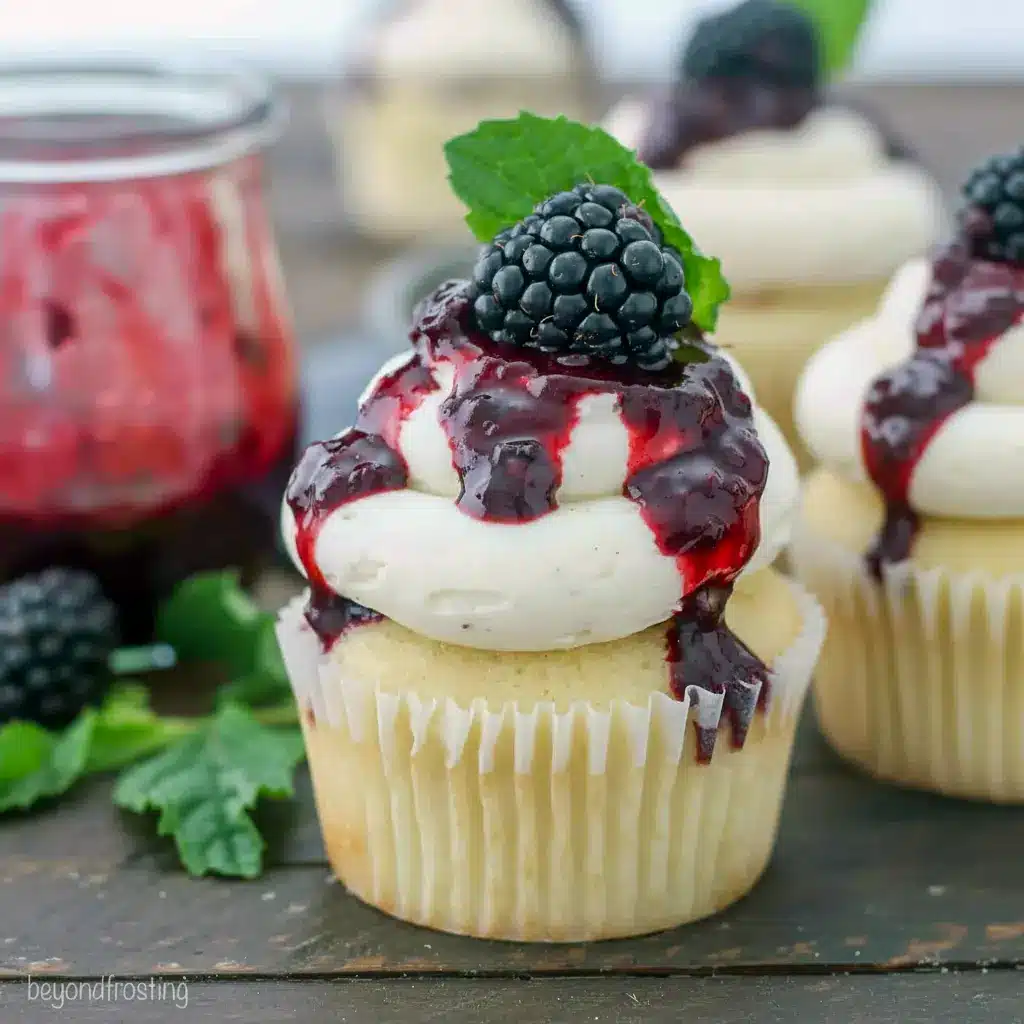 Close-up of a frosted cupcake with blackberry drizzle and a mint garnish — adult party treat for Liquor Desserts, ideal for Baking With Alcohol, and a top pick among Booze Desserts, Easy Alcohol Dessert Recipes.