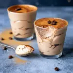 Close-up of a layered chocolate-coffee mousse in a glass, dusted with cocoa and topped with a coffee bean — a decadent Keto Tiramisu that reads like a Keto Chocolate Cheesecake Mousse and works as a quick Keto Tiramisu Recipe Without Mascarpone, Keto Tiramisu Mousse.