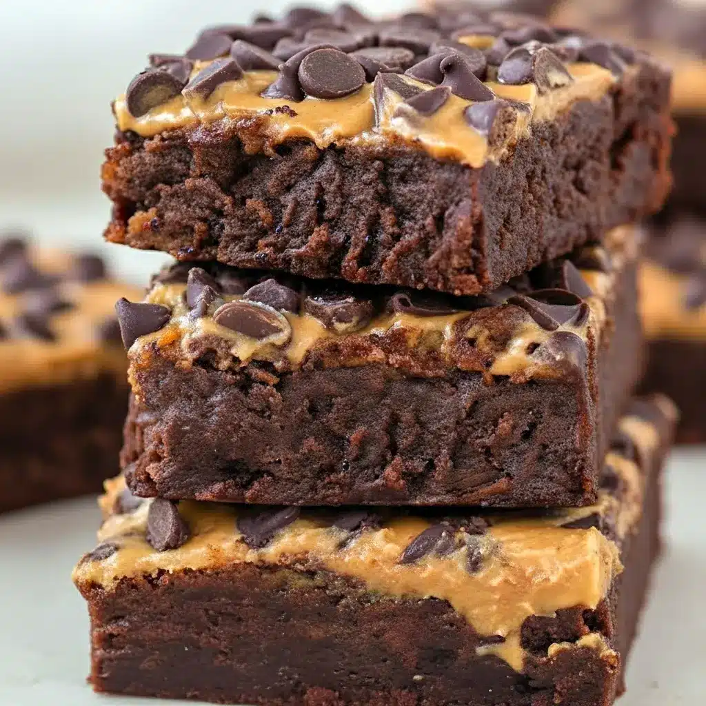Stacked pumpkin-chocolate brownie bars on parchment, topped with a smear of peanut butter and sprinkled mini chocolate chips, Pumpkin Workout Brownies.