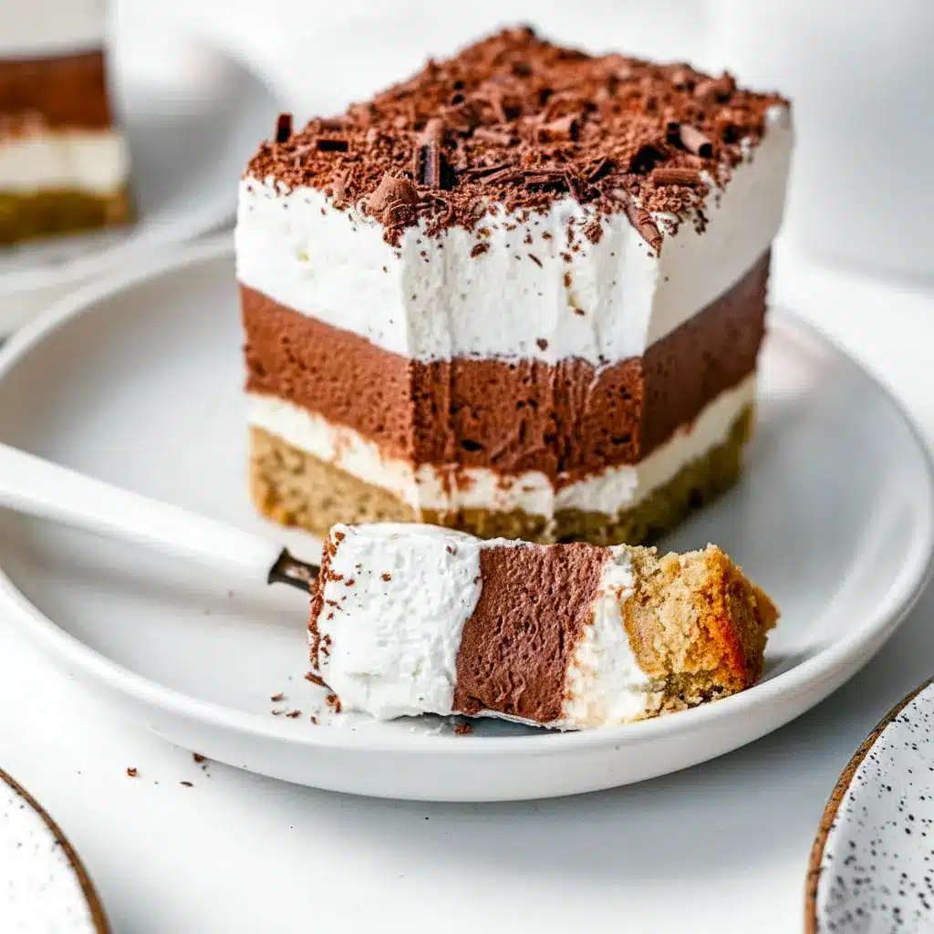No-bake keto layered dessert with pecan crust, creamy sugar-free cream-cheese layer, chocolate pudding layer and whipped topping, sliced on a serving plate.
