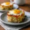 Breakfast And Brunch Ideas: golden baked eggs napoleon in puff pastry cups with spinach and melted cheese, garnished with chopped chives on a white plate.