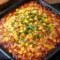Close-up of a golden Baked Corn Casserole topped with honey glaze and melted cheese, sliced and ready to serve — a delicious Corn Side Dish Recipes example and classic Corn Recipe for holidays.