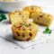 Cottage Cheese Egg Bites Recipe — close-up of golden, baked egg bites in a muffin tin, topped with chopped chives and crispy bacon, ready to serve.