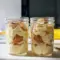 Creamy jar of Healthy And Easy Desserts protein banana pudding layered with crushed vanilla wafers and banana slices.