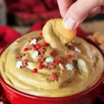 Bowl of creamy gingerbread dip topped with festive sprinkles, surrounded by mini Nilla wafers and graham crackers on a wooden board, Winter Dip Recipes.