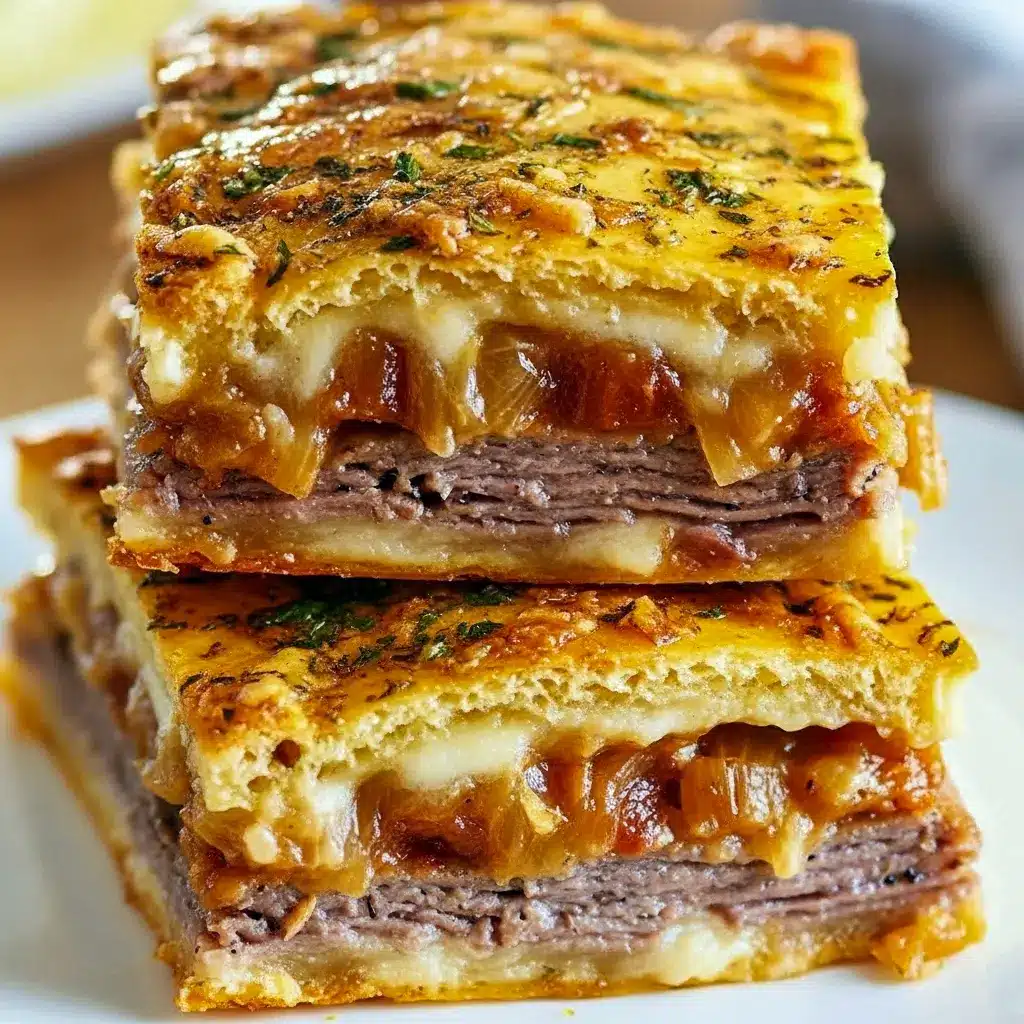 Stacked golden French Dip Squares on a white plate with melted cheese and caramelized onions, a small bowl of steaming au jus for dipping in the background, Holiday Dinner Inspiration.