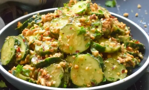Bowl of Peanut Sauce Cucumber Salad: sliced cucumbers coated in spicy peanut dressing, topped with toasted peanuts and parsley — a bright Peanut Butter Lunch or side dish.
