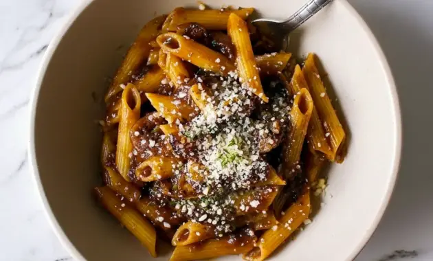 Close-up of Balsamic Mushroom Pasta coated in a glossy Balsamic Sauce For Pasta, finished with grated Parmesan and fresh thyme.