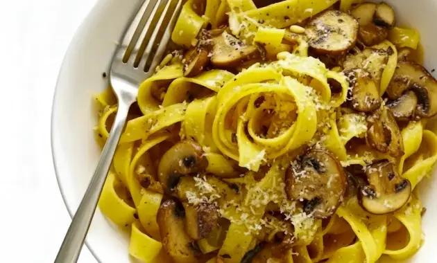 Close-up of a pappardelle bowl piled with golden, balsamic-glazed mushrooms and grated Parmesan — a hearty Mushroom Lovers Pasta shot highlighting a warm Vegetarian Pasta With Mushrooms serving.