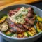 Bowl with sliced grilled steak, charred zucchini, rice, and creamy herb sauce — a Unique Meal Prep bowl that also works as a Healthy Whole Foods Recipe.