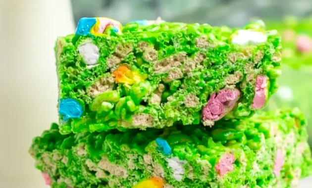 Close-up of a green Lucky Charms Rice Krispie square with marshmallow bits and a glossy finish — St Pats Day Snacks and St Patrick Day Treats styled on a festive platter.