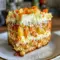 Slice of Hawaiian Pineapple Carrot Cake on a plate, topped with cream cheese frosting and visible pineapple bits — moist, spiced, and ready to enjoy.