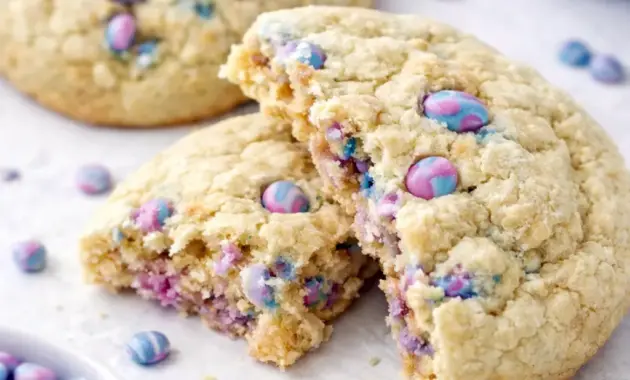 Warm Protein Sugar Cookies stacked on parchment, showing a soft, cakey texture and white chocolate center.