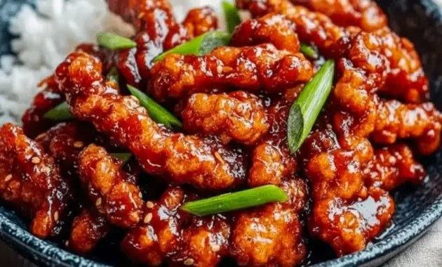 Dragon Chicken glazed in sticky Sweet And Spicy Sauce, topped with sliced green onions and sesame seeds, served over jasmine rice.