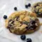 Thick Blueberry Muffin Cookies with golden streusel, jam pockets, and plump blueberries on parchment — close-up of a chewy, bakery-style cookie.