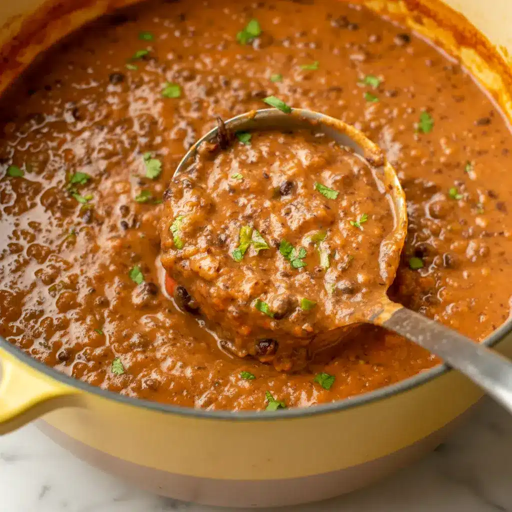 Steaming bowl of Black Bean Soup topped with cilantro, avocado, and a lime wedge — a simple Homemade Black Bean Soup ready in half an hour.