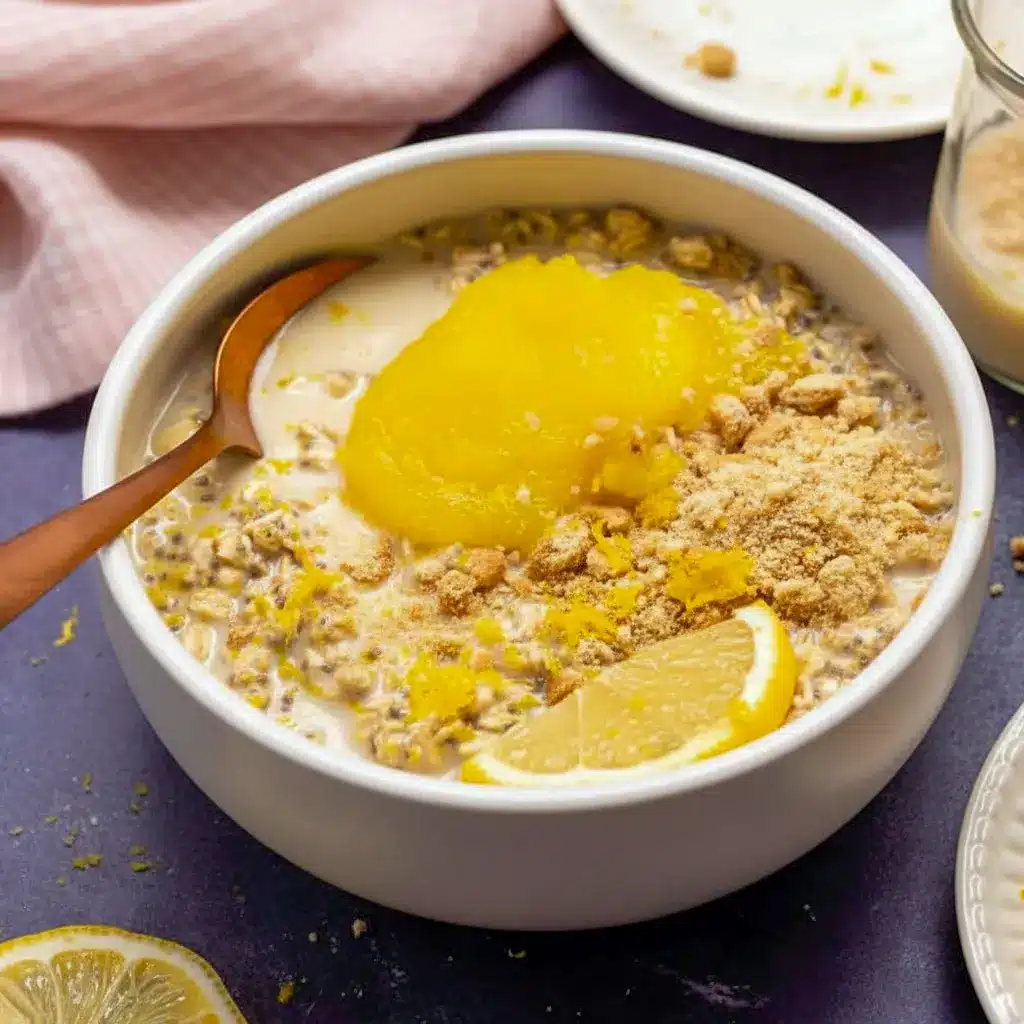 Lemon Cheesecake Overnight Oats in a jar, creamy and pale yellow, topped with lemon zest and fresh berries — a ready-to-eat Creamy Lemon Overnight Oats breakfast.