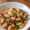 Skillet of creamy Tuscan Butter Beans with wilted spinach and sun-dried tomatoes — rustic Butter Beans Recipe served as a tasty Vegetable Side Dishes option.