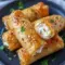 Oven Fried Feta Rolls With Chili Honey on a wooden board — golden, flaky rolls drizzled with sticky chili honey, a perfect Flaky Chili Honey Feta Rolls Appetizer.