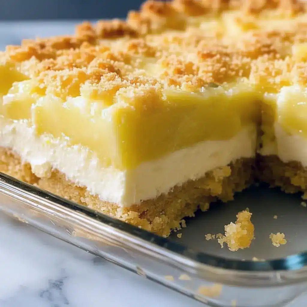 Lemon Cream Cheese Dump Cake — slice of golden crumb-topped cake showing bright lemon filling and a creamy layer, plated with a dollop of whipped cream.