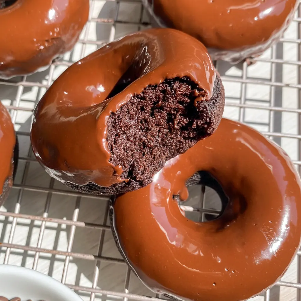 Chocolate Protein Donuts — six chocolate-glazed donuts on a wire rack, showing moist interior and glossy dark-chocolate finish, paleo and gluten-free.
