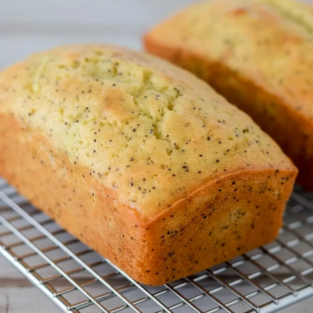 A sliced loaf of Lemon Poppy Seed Zucchini Bread with a soft golden crumb and visible poppy seeds, styled as a fresh Lemon Poppy Seed Dessert for Spring Baking Ideas.
