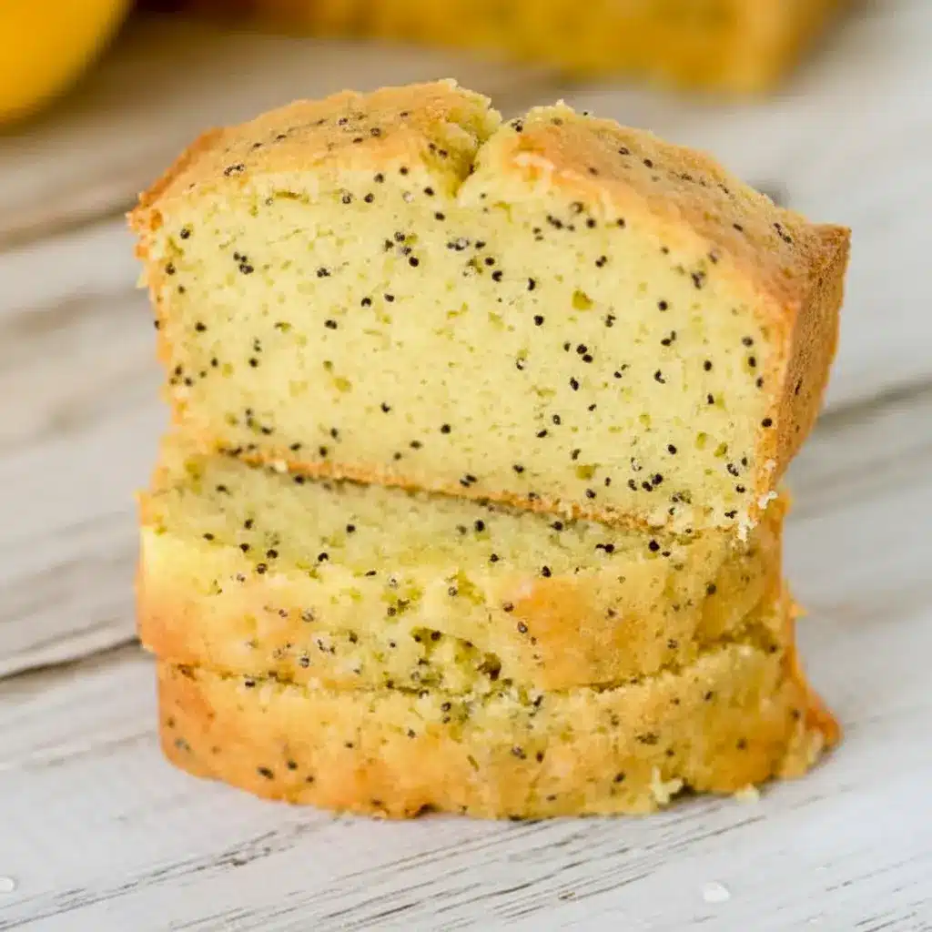 A sliced loaf of Lemon Poppy Seed Zucchini Bread with a soft golden crumb and visible poppy seeds, styled as a fresh Lemon Poppy Seed Dessert for Spring Baking Ideas.
