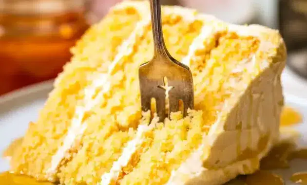 Close-up of a slice of Cornbread Cake layered with whipped honey buttercream, golden cornmeal crumb, and a honey drizzle — a rustic Cornbread Layer Cake that reads like a Cake Like Cornbread Recipe.