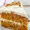 A beautifully layered Carrot Cake Recipe with fluffy Cream Cheese Frosting, featuring a thick slice that shows its tender crumb and rich texture. This Super Moist Carrot Cake is decorated with smooth frosting and simple carrot garnish, making it the perfect Easter Dessert or classic homemade cake for celebrations.