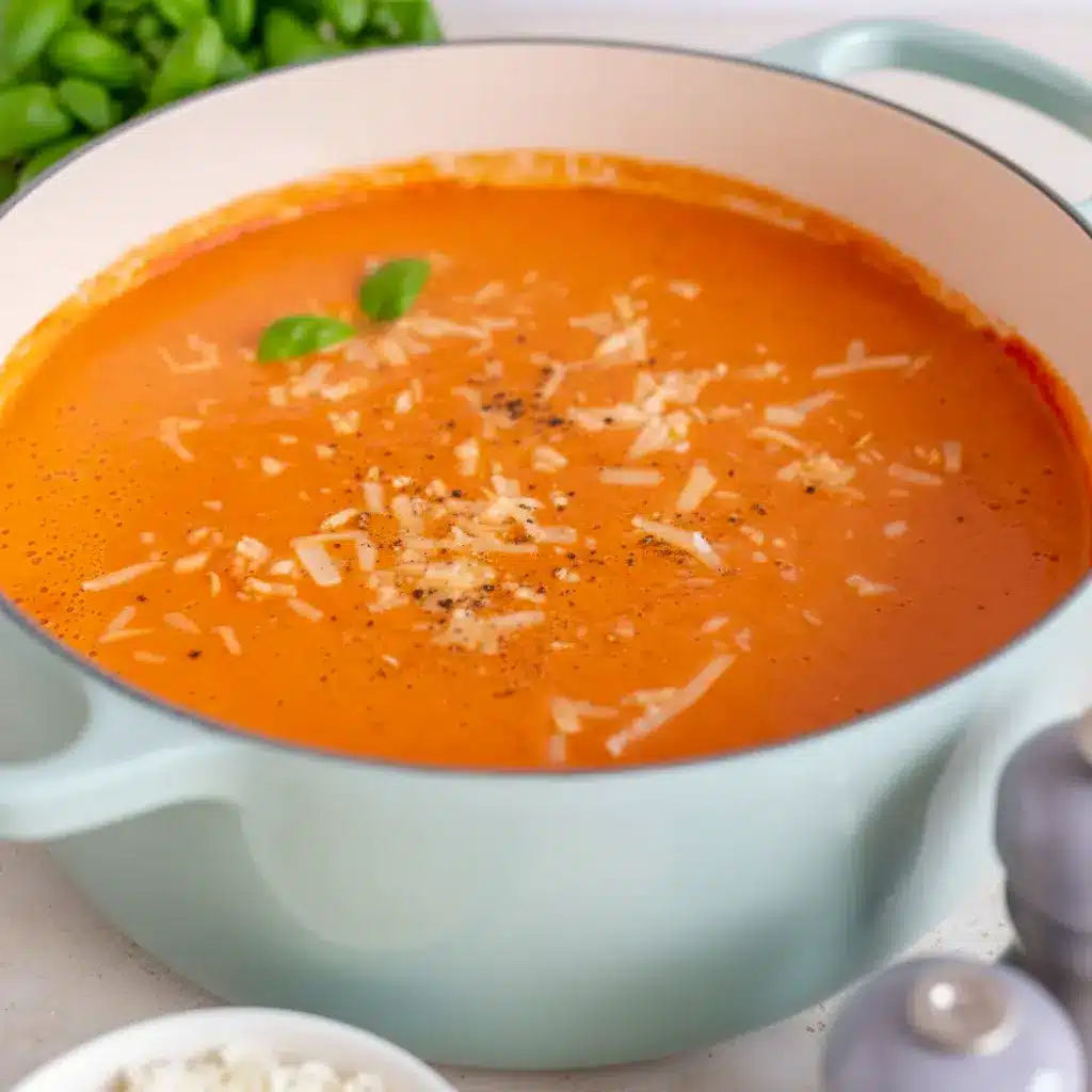 A serving bowl of High Protein Tomato Soup with crusty bread on the side, ideal for Canned Tomato Recipes Dinner inspiration.