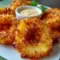 Fried Pineapple rings with a crispy coconut coating and rum-infused dipping sauce, a delicious choice for Pineapple Recipes, Fruit Recipes, and festive Appetizer Snacks.