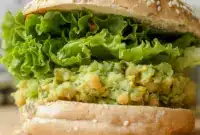 Smashed Chickpea Avocado Dill Pickle Sandwiches on whole grain bread with crisp lettuce and Avocado Chickpea Salad Sandwich filling for an easy healthy lunch.